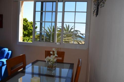 a dining room with a glass table and a window at Apartamento Atis Tirma in Gran Tarajal
