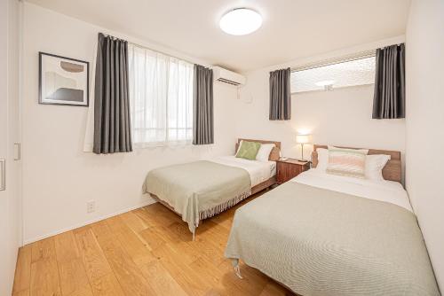 a bedroom with two beds and a window at Oasis Omori New House - 30min to Haneda - 2 Adjacent Homes in Tokyo