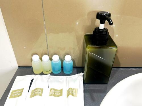 a close up of a bottle of soap and three bottles of water at Unixx Sea view Holiday Hotel in Pattaya South