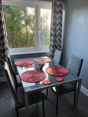 tavolo da pranzo con 2 piatti rossi di Apartment 288 a Lower Swanwick