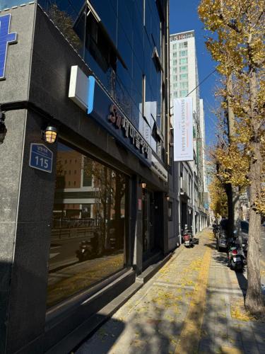 an empty city street with buildings and a street sign at Designers Stay Busan in Jung-gu