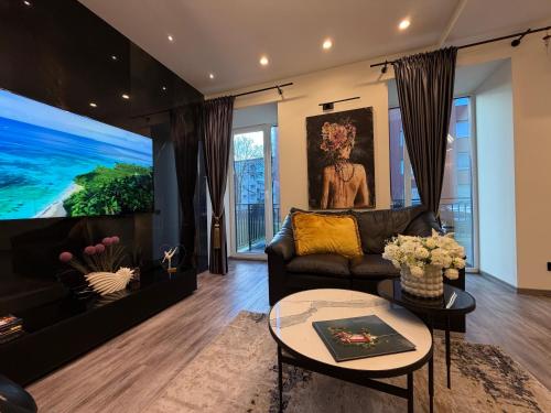 a living room with a couch and a tv at Koralas in Klaipėda