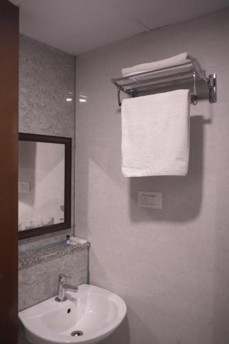 a bathroom with a sink and a mirror and a towel at Hotel UR Comforts Jayanagar in Bengaluru