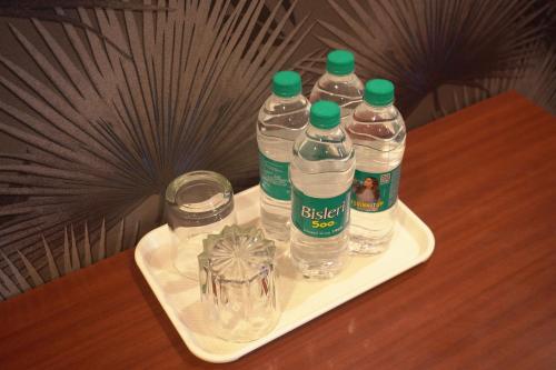 three bottles of water on a tray on a table at Hotel UR Comforts Jayanagar in Bengaluru