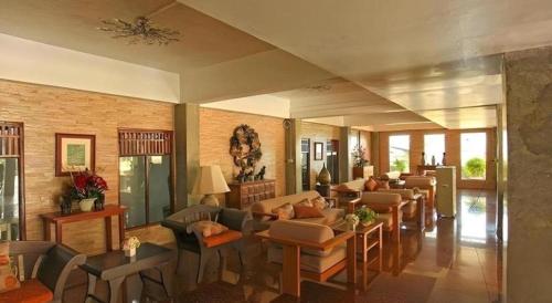 a living room with couches and tables and chairs at Ladawan Boutique Hotel in Ban Pak Khlong