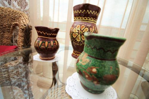three vases are sitting on a glass table at Mai Danube in Eşelniţa