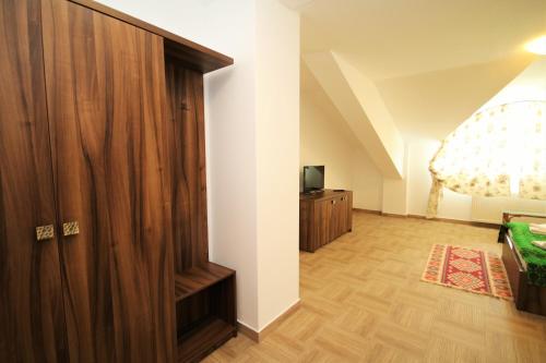 a room with a wooden closet and a television at Mai Danube in Eşelniţa
