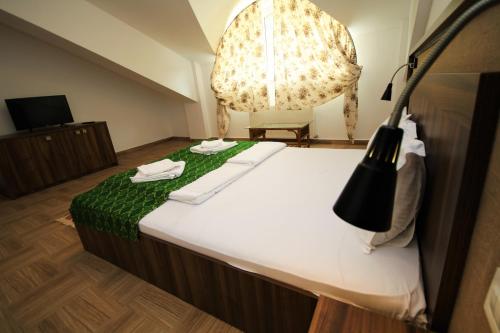 a bedroom with a large bed with a green blanket at Mai Danube in Eşelniţa