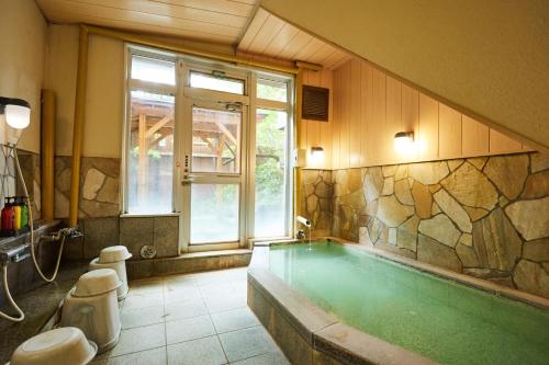 um banheiro grande com banheira, janela e banheira em ゆのホテル奥日光やまみず樹 em Yumoto
