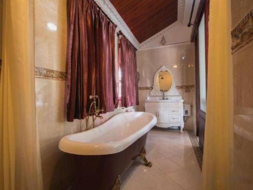 a bathroom with a tub and a sink and a mirror at The View Pavilion Hotel in Luang Prabang