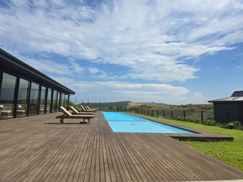 een terras met ligstoelen naast een zwembad bij FezatOceanZimbali in Ballito