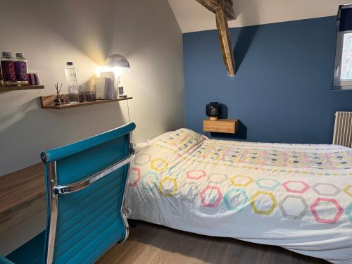 a bedroom with a bed with a blue wall at La chambre du Parc in Amiens