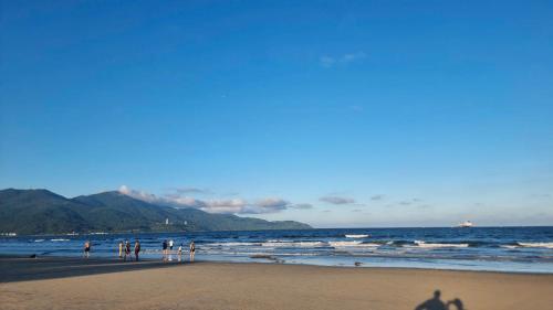 eine Gruppe von Menschen steht am Strand in der Unterkunft Full House Hotel Apartment in Đà Nẵng