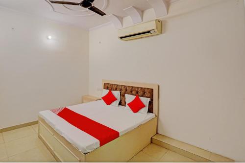 een slaapkamer met een bed met rode en witte lakens bij Hotel O Krishna Inn in Ghaziabad