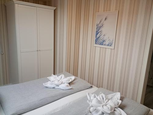 ein Schlafzimmer mit einem Bett mit zwei weißen Blumen darauf in der Unterkunft Ferienwohnung Nordlicht in Hage