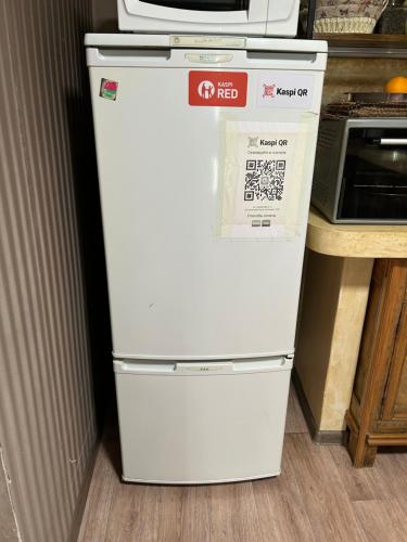 Sweet Home Art Boutique في شيمكنت: وجود ثلاجة بيضاء في مطبخ بجانب كونتر