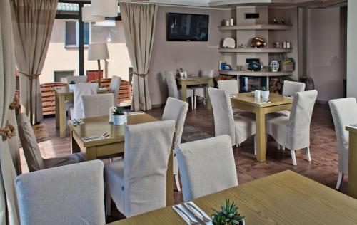 a dining room with tables and chairs and tablesktop at Hotel 77 Restauracja Spa in Chałupy