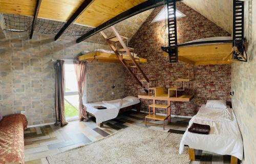 Sweet Home Art Boutique في شيمكنت: غرفة بها سريران ودرج في جدار من الطوب