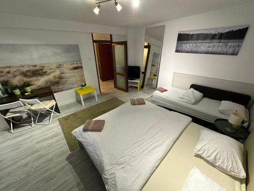 a bedroom with a large white bed and a table at New Green Apartment Studio 1 in Bucharest