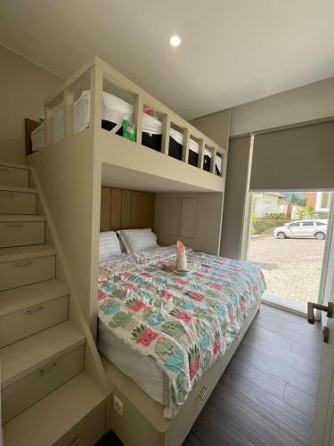 a bedroom with a bunk bed with a bedspread at Orlando Hill Villa in Ngadisari