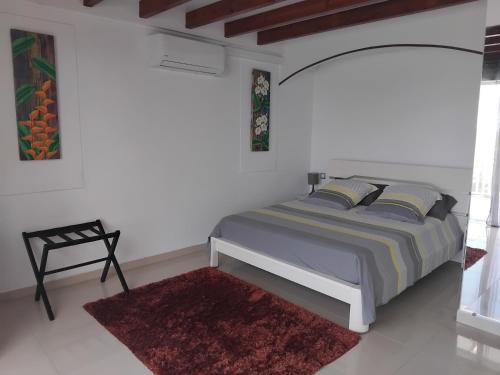 a bedroom with a bed and a red rug at Kote mer Villa Bayside in Sainte-Anne