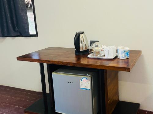 een tafel met een telefoon bovenop een koelkast bij New Ozone Resort & Spa in Koh Lanta