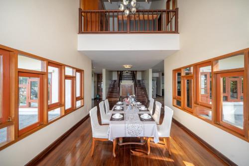 a dining room with a long table and white chairs at Villa Moon Talay View in Patong Beach