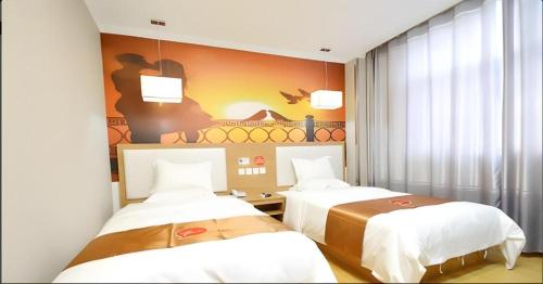 a room with two beds and a painting on the wall at Thank Inn Hotel He'nan Xuchang Railway Station Qiyi Road Caowei Ancient Town in Xuchang