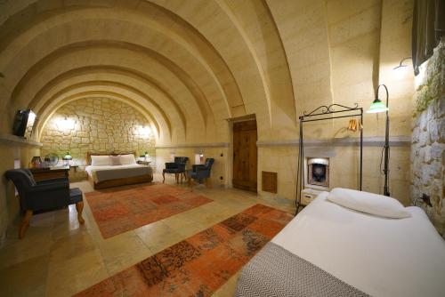 a large room with a bed and a fireplace at Design Cave Hotel in Goreme