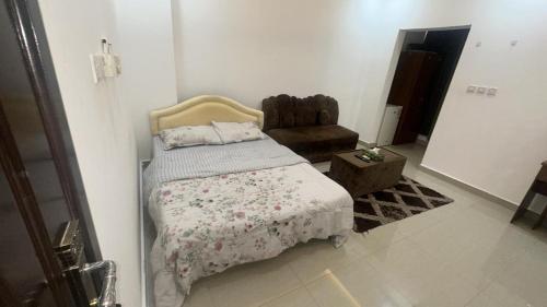 ein Schlafzimmer mit einem Bett und einem Stuhl darin in der Unterkunft Raha rooms in Seeb