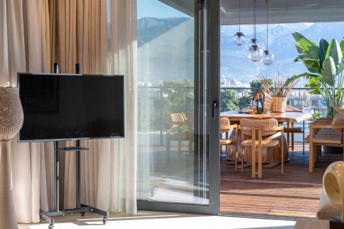 カラマタにあるElektra Roof Top Suiteの壁に薄型テレビが取り付けられたリビングルーム