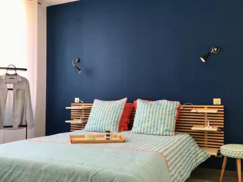 ル・グロー・デュ・ロワにあるVilla de standing en bord de merの青い壁のベッドルーム1室、ベッド1台が備わります。