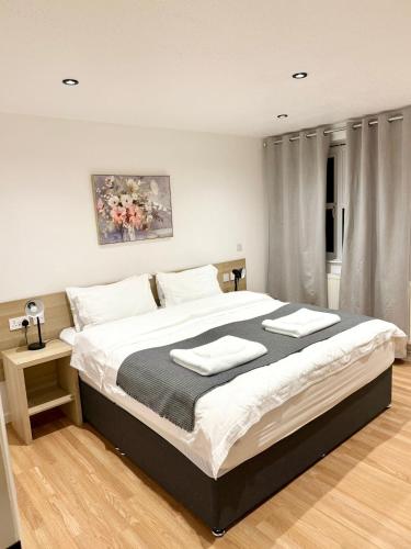 a bedroom with a large bed with two towels on it at Oxford city centre Modern 2-Bed flat in Oxford