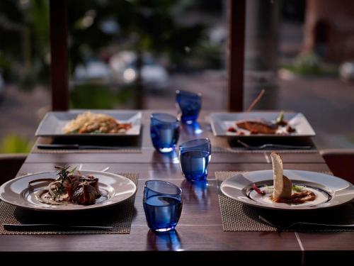 a wooden table with plates of food and glasses on it at Pullman Hanoi in Hanoi