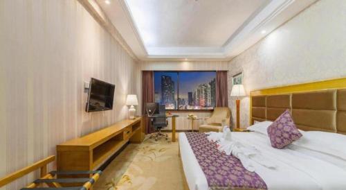 a hotel room with a bed and a television at Xiamen Plaza Hotel in Xiamen