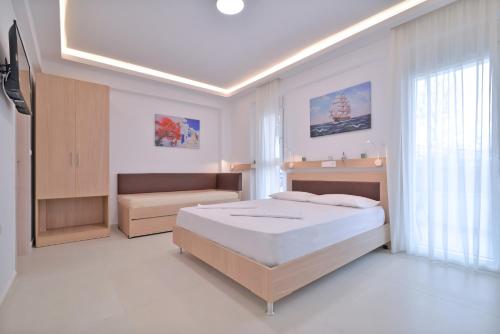Un dormitorio blanco con una cama y un sofá. en Evas Rooms, en Neoi Poroi