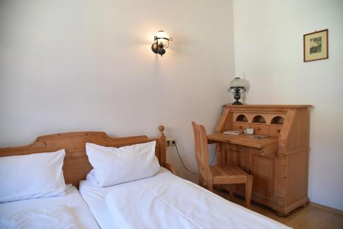 a bedroom with two beds and a desk with a lamp at Altstadthotel Garni Schlundhaus & Rautenkranz in Meiningen