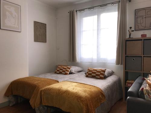 a bedroom with a bed and a window at l'Aiglon in LʼAigle