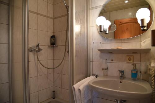 a bathroom with a shower and a sink and a mirror at Altstadthotel Garni Schlundhaus & Rautenkranz in Meiningen