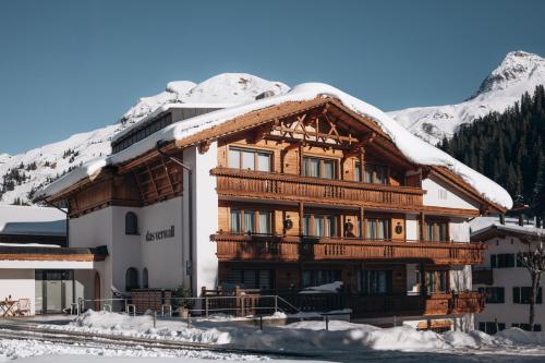 ein großes Gebäude mit Schnee auf dem Dach in der Unterkunft Das Verwall Finest Apartments in Lech am Arlberg