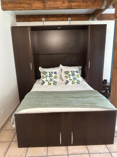 PréneronにあるCelinaturaの大型ベッド1台(木製ヘッドボード付)が備わるベッドルームです。