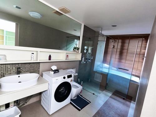 a bathroom with a washing machine and a sink at Beachfront Patong Hillside Modern Apartment in Patong Beach