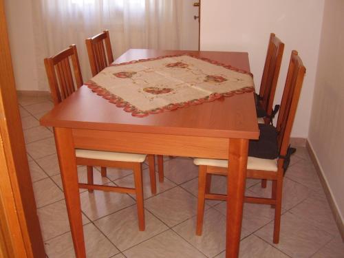 a wooden table with chairs and a table cloth on it at Jean Home in Gallarate