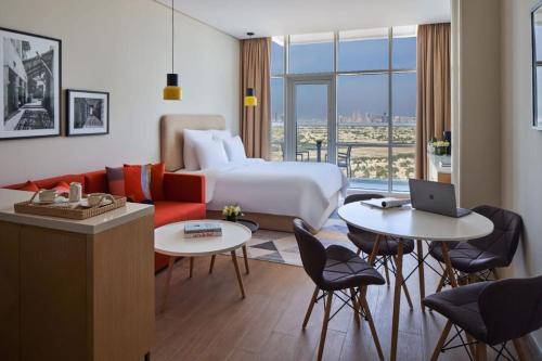a hotel room with a bed and a couch and tables at Luxery Hotel Apartment l Novotel Residence l JVT in Dubai