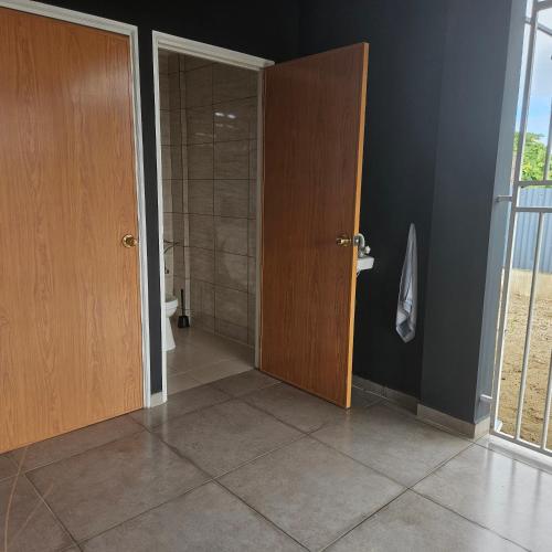 a bathroom with a shower and two wooden doors at Jawala Mansion in Paramaribo