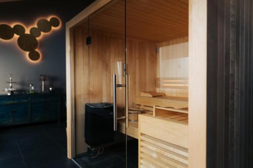baño con sauna con puerta de cristal en The Kepos Hotel Erlangen, en Erlangen