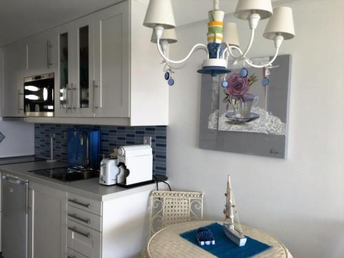 a kitchen with a table and a chandelier at Sun & Sea 512 in Sesimbra