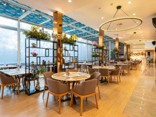 a restaurant with tables and chairs in a room at Pullman Guiyang in Guiyang