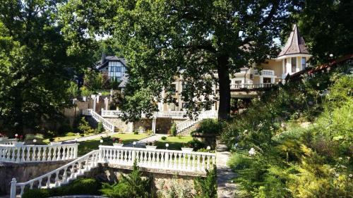 a large house with a white fence in front of it at Gnizdo Golubky in Shaian