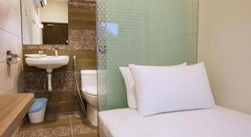 a small bathroom with a bed and a sink at Tropicana Boutique Hotel in Kampung Tanjung Agas